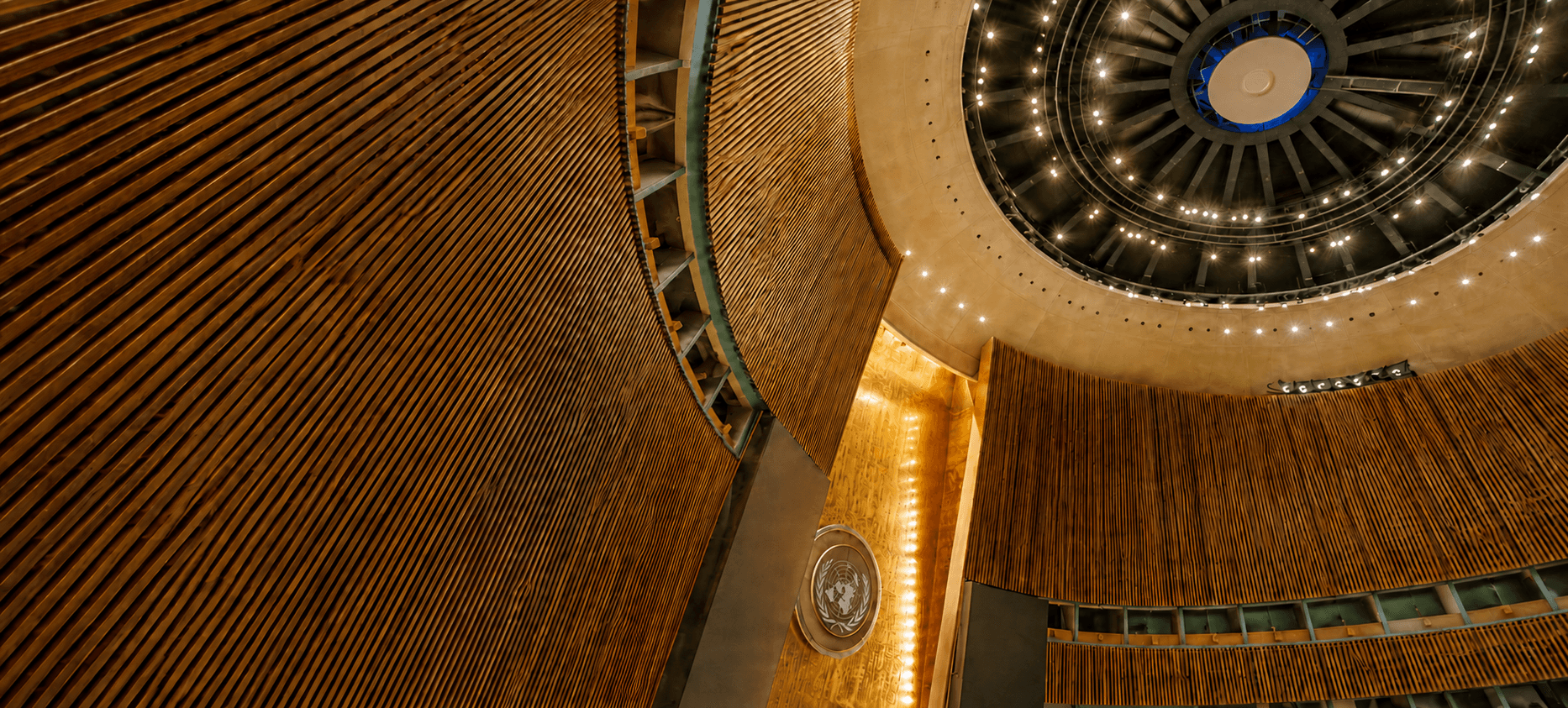 Interior view of the United Nations General Assembly Hall featuring wooden walls and domed ceiling.